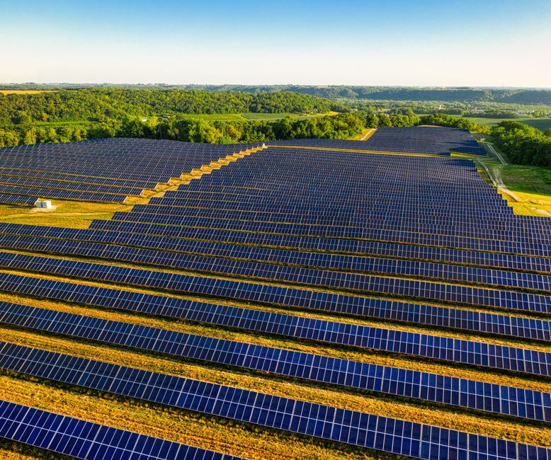 Een afbeelding van zonnepanelen en een laadpaal bij een moderne woning, symboliserend energiebeheer.